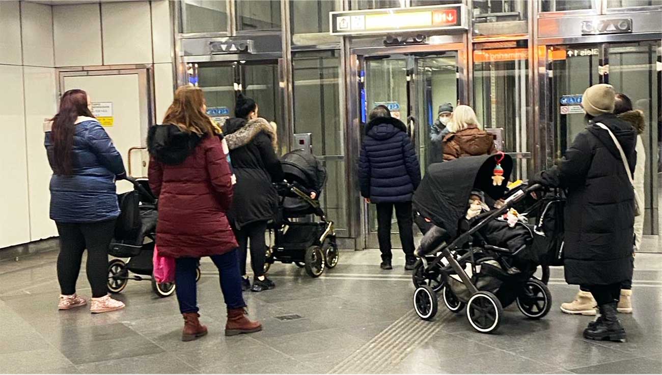 A huddle of mothers with prams waiting for a lift on Vienna's metro