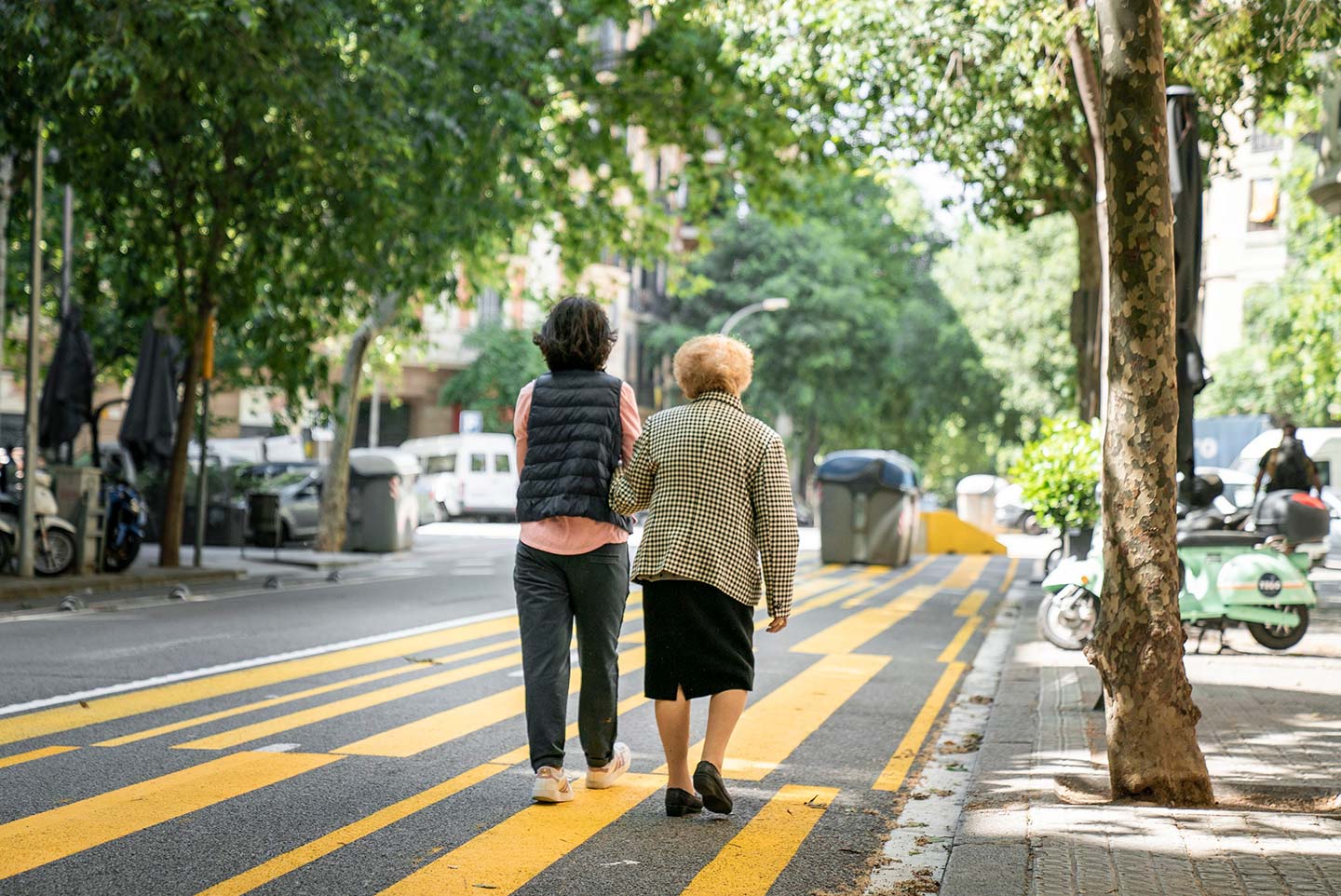 Barcelona-Monica-Moreno-1440 Two women walking arm in arm in Barcelona.