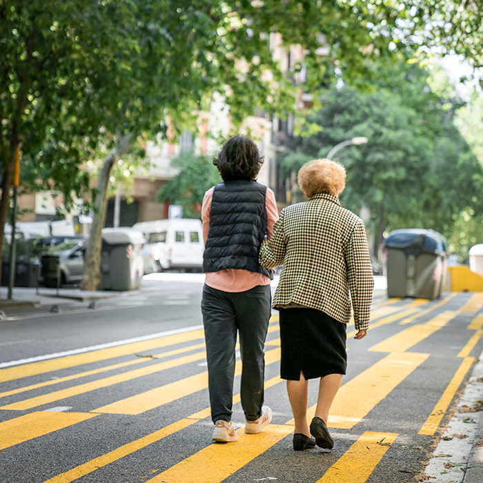 A younger woman walking with an older woman in Barcelona.